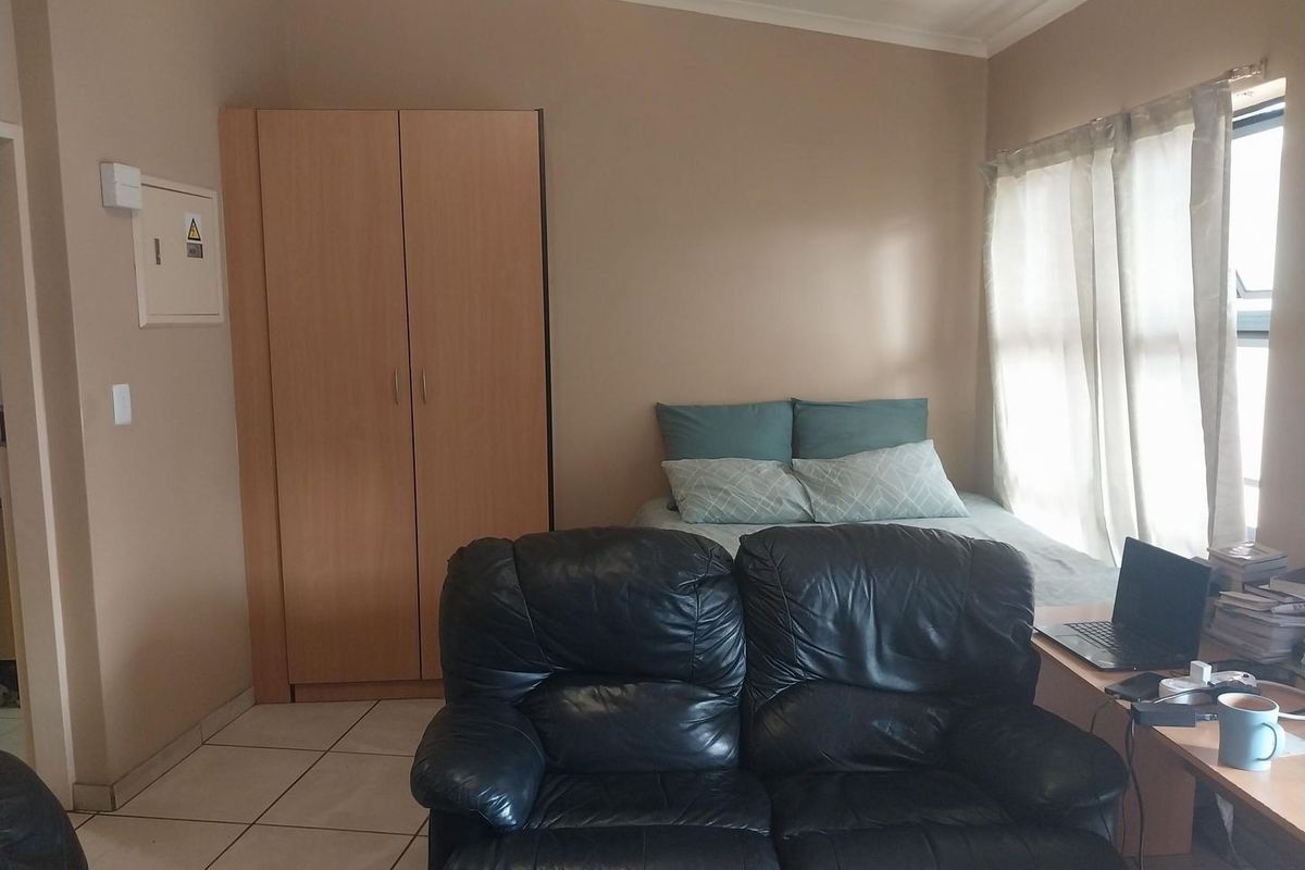 A bedroom featuring tiled flooring, a built-in wardrobe, and an integrated electrical distribution board.
