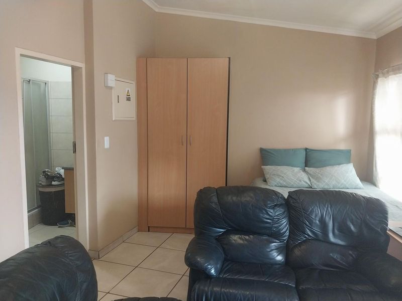 A bedroom featuring tiled flooring, a built-in wardrobe, and direct access to an en-suite bathroom.