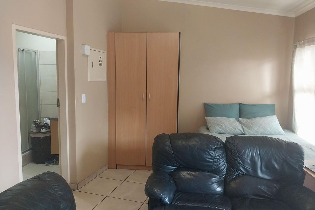A bedroom featuring tiled flooring, a built-in wardrobe, and direct access to an en-suite bathroom.
