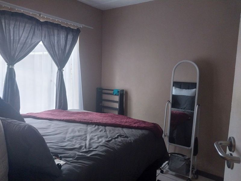 A standard bedroom featuring tiled flooring and neutral wall tones, providing a functional and comfortable living space.