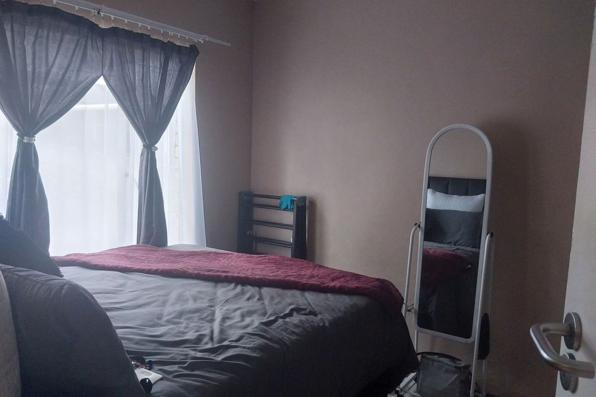 A standard bedroom featuring tiled flooring and neutral wall tones, providing a functional and comfortable living space.