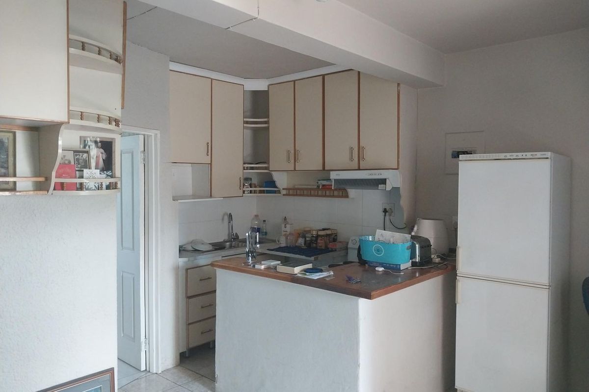 Compact kitchen featuring built-in cabinetry, a breakfast counter, and a functional layout, offering potential for modernization and aesthetic updates.