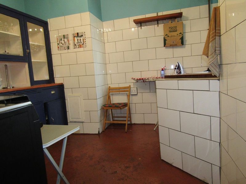 A functional laundry area featuring subway tile wall cladding, built-in cabinetry, and a tiled utility counter, offering a practical space for household tasks.
