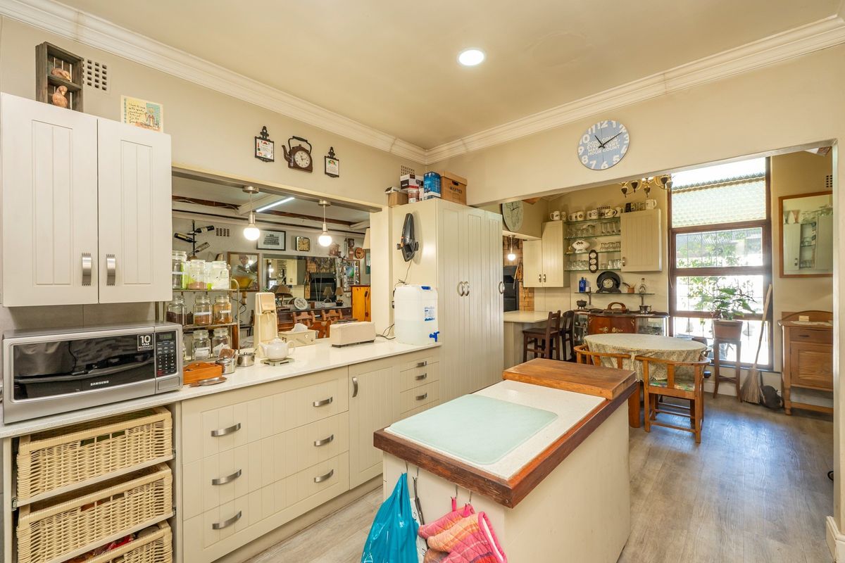 A functional kitchen featuring ample built-in cabinetry, a central island with a wooden countertop, and recessed lighting, offering a practical layout for daily use.
