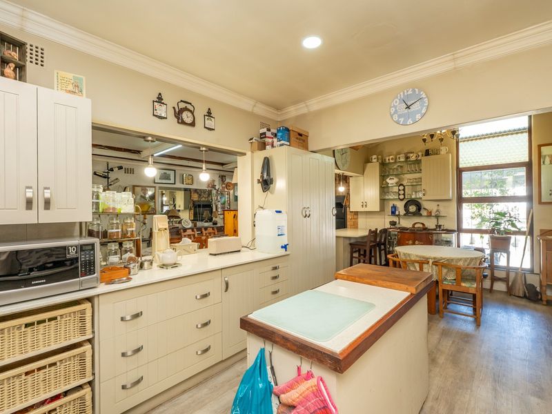 A functional kitchen featuring ample built-in cabinetry, a central island with a wooden countertop, and recessed lighting, offering a practical layout for daily use.