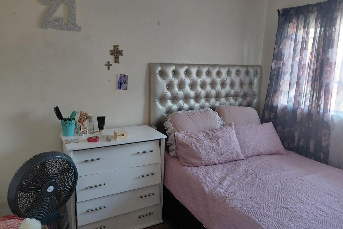 A standard bedroom featuring a window with curtains and neutral wall finishes, providing a functional space for rest.