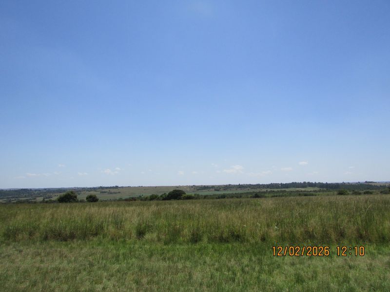 A wide-angle view of the expansive open grassland and rural landscape surrounding the property.