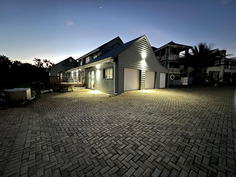 A well-maintained residential property at dusk, featuring a triple garage, paved driveway, and an attached timber deck.