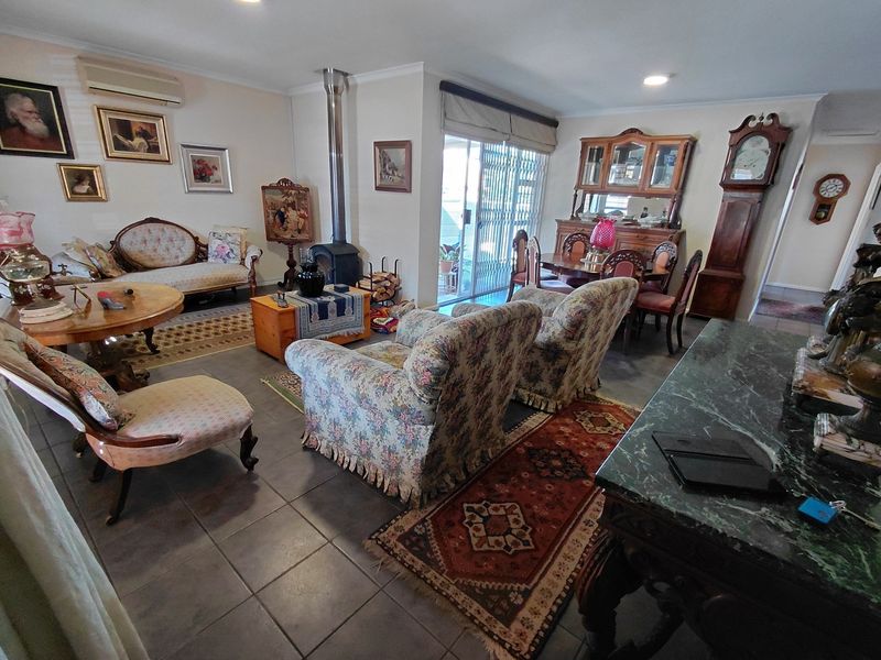 Spacious open-plan living and dining area featuring tiled flooring, a freestanding fireplace, and direct access to the outdoor space via sliding glass doors.