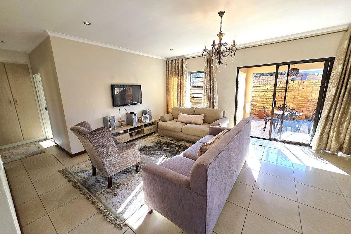 Spacious living room featuring tiled flooring, recessed lighting, and large sliding glass doors providing direct access to the outdoor patio area.