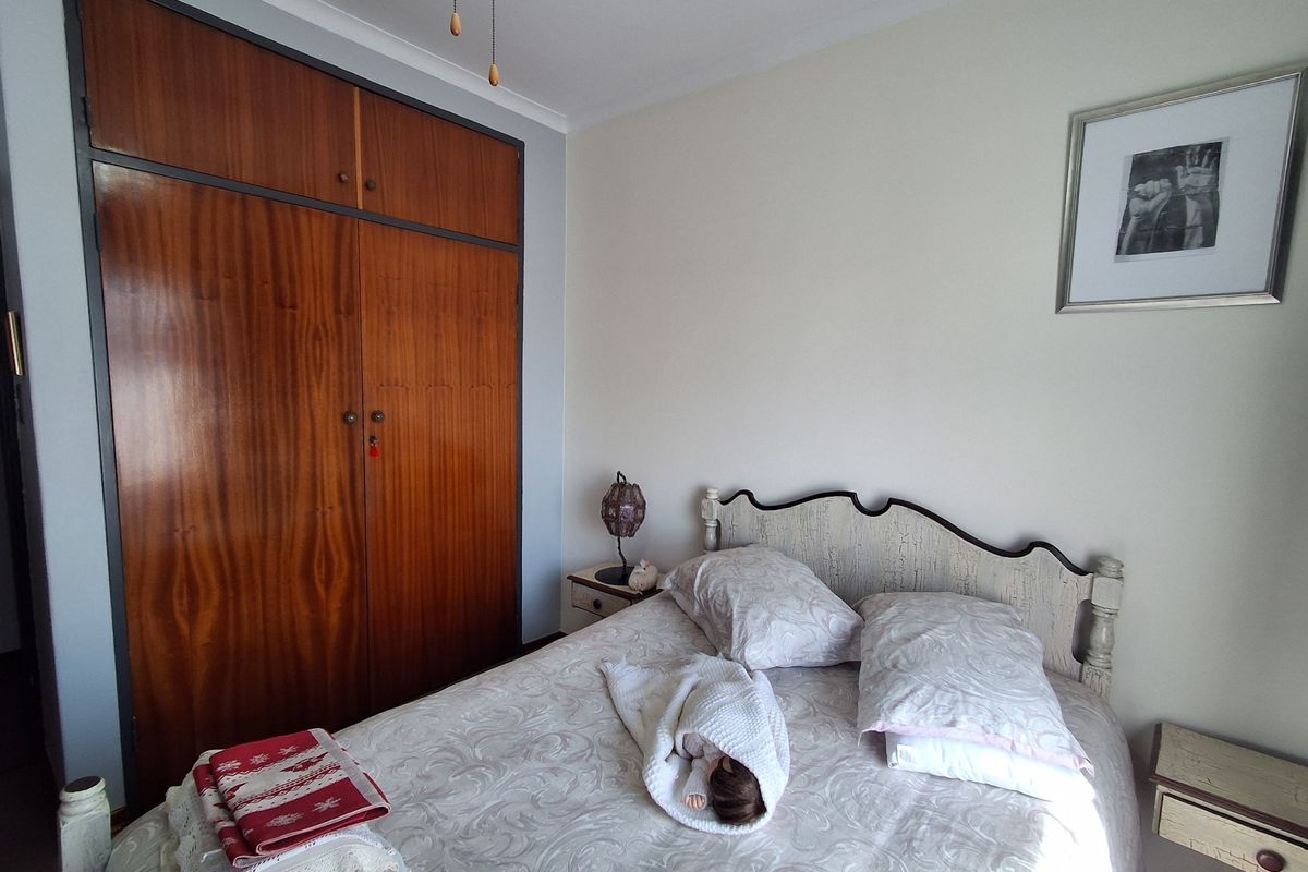 A bedroom featuring a large built-in wooden wardrobe with classic cabinetry and neutral wall finishes.