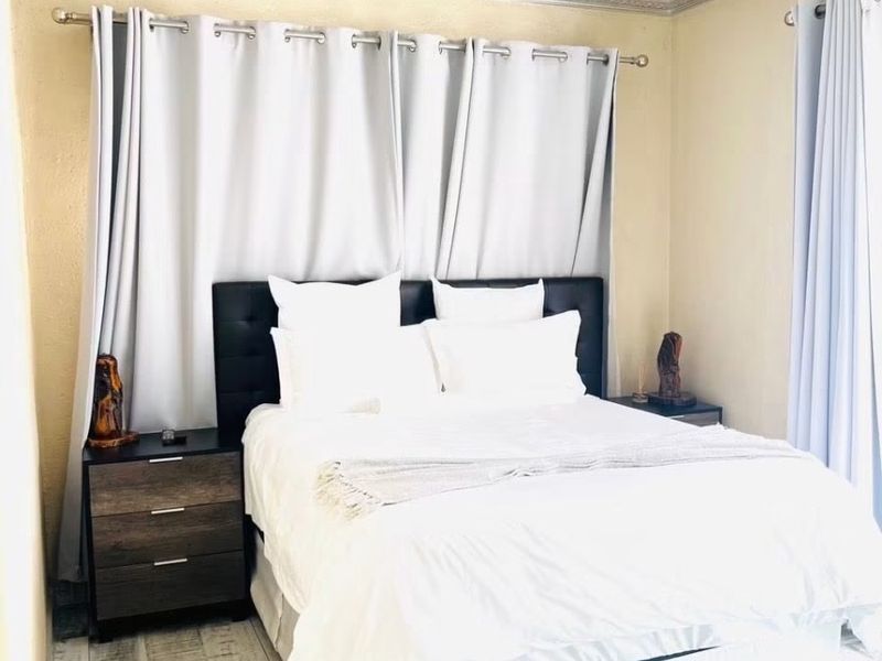 A bedroom featuring tiled flooring and crown molding, providing a neutral foundation for personalization.