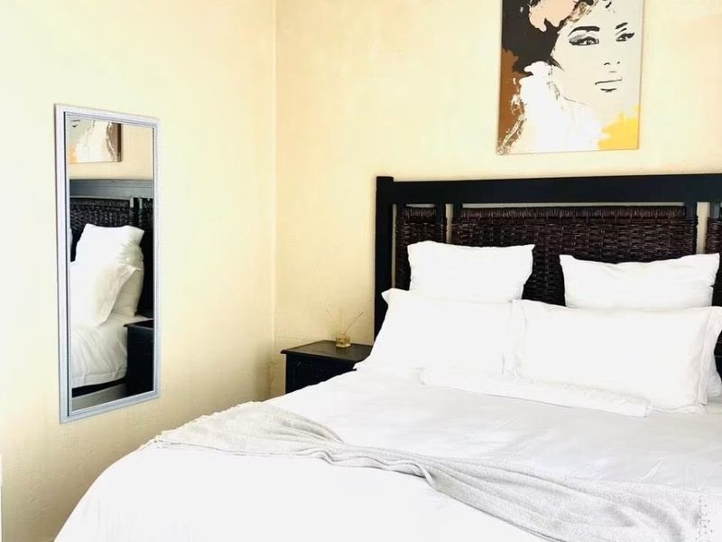A bedroom featuring neutral wall tones and decorative coving, providing a simple and functional sleeping space.