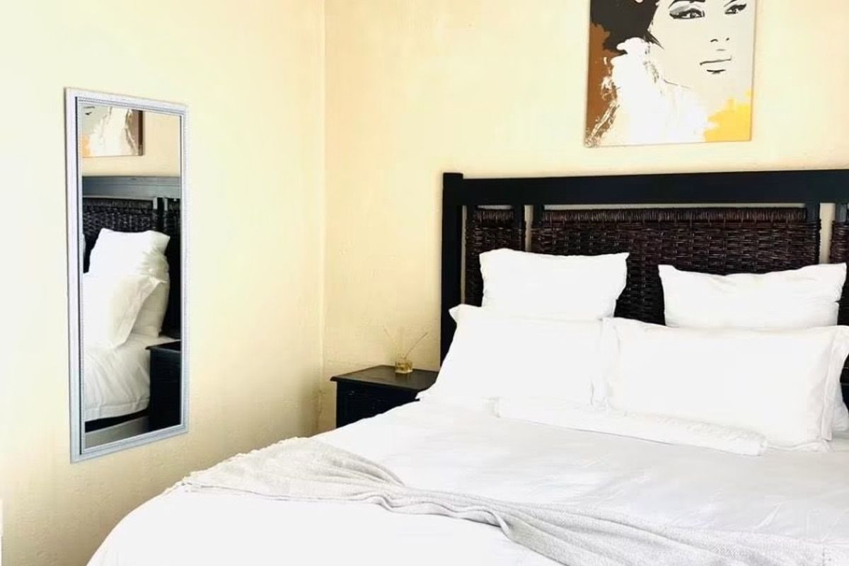 A bedroom featuring neutral wall tones and decorative coving, providing a simple and functional sleeping space.