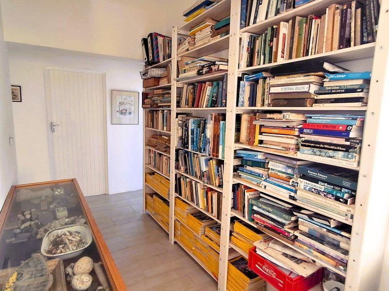 A functional hallway space featuring tiled flooring and ample wall-mounted shelving units for storage.
