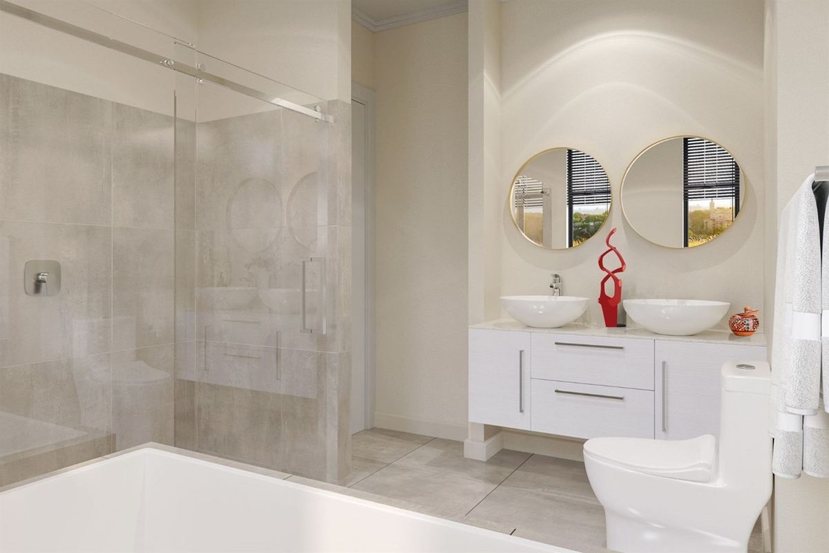 Modern bathroom featuring a double vanity with vessel sinks, a walk-in shower with glass enclosure, and contemporary tiled finishes.