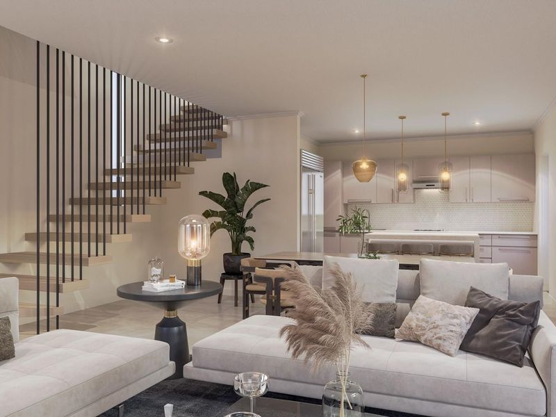Modern open-plan living area featuring a contemporary floating staircase with metal balustrade, seamlessly flowing into a sleek, well-appointed kitchen with island seating.