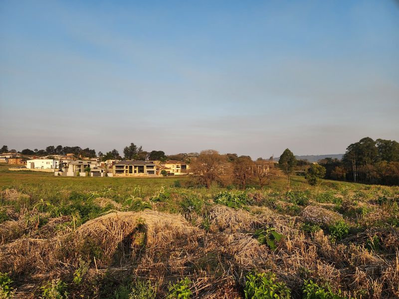 A view of the vacant residential land with surrounding neighborhood houses visible in the distance.