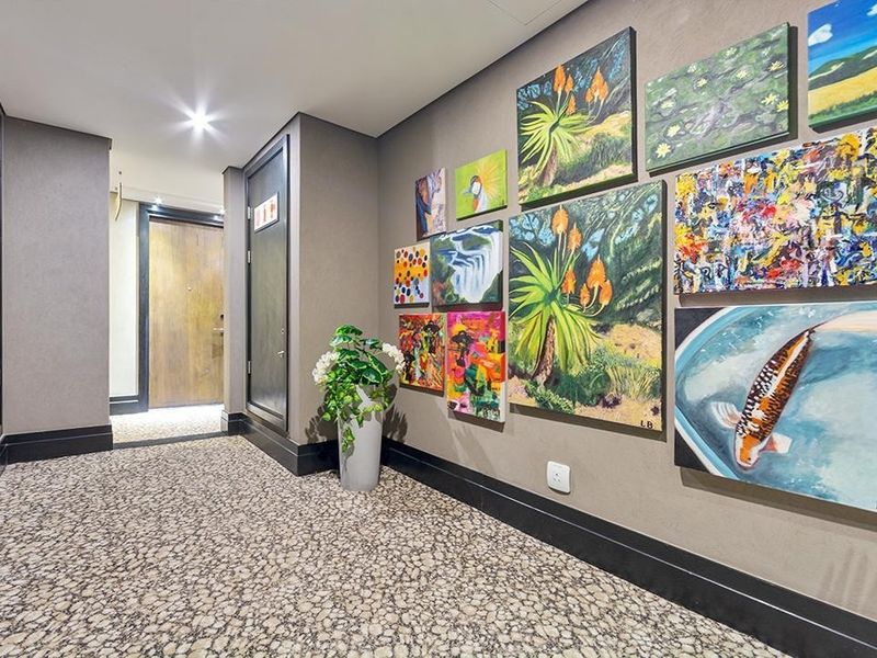 A well-maintained apartment hallway featuring neutral wall tones, recessed lighting, and patterned carpeting, providing a clean and welcoming transition space.