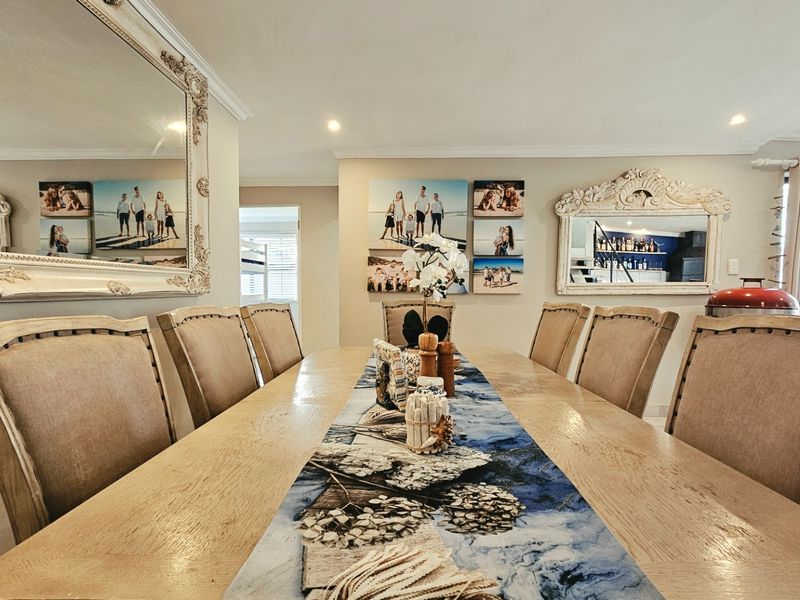 A well-maintained dining room featuring tiled flooring, recessed downlighting, and decorative coving, providing a bright and inviting space for family meals.