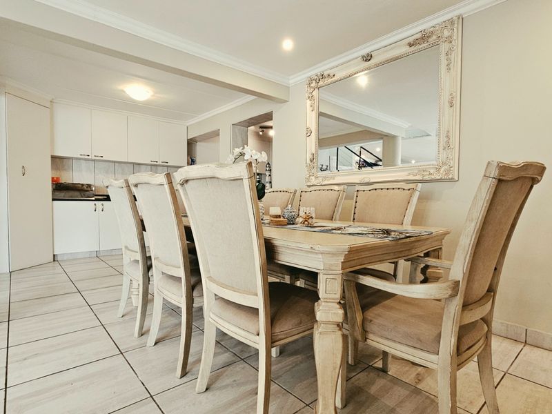 Open-plan dining area featuring tiled flooring, recessed lighting, and integrated kitchen cabinetry, creating a cohesive and functional living space.