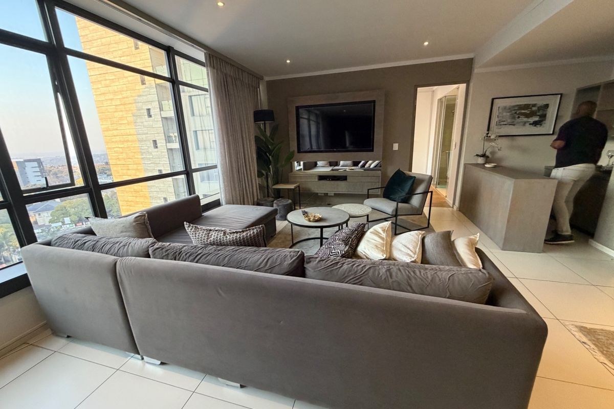 Modern living room featuring floor-to-ceiling windows with expansive views, tiled flooring, and a built-in media console.