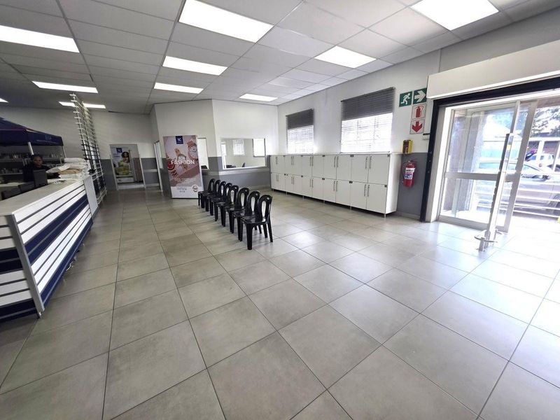 A commercial entrance area featuring tiled flooring, suspended ceiling with recessed lighting, and built-in storage cabinetry along the wall.