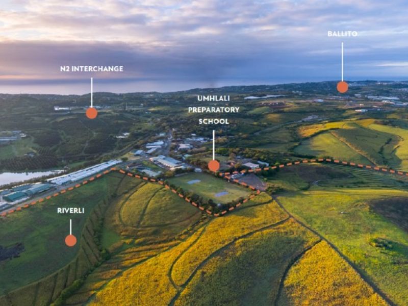Aerial view of the agricultural land showing surrounding landmarks, including schools, transport interchanges, and coastal towns in the distance.