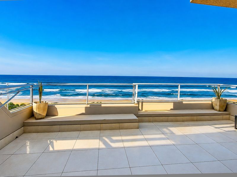 Spacious balcony featuring tiled flooring, built-in bench seating, and a glass balustrade, offering panoramic ocean views.