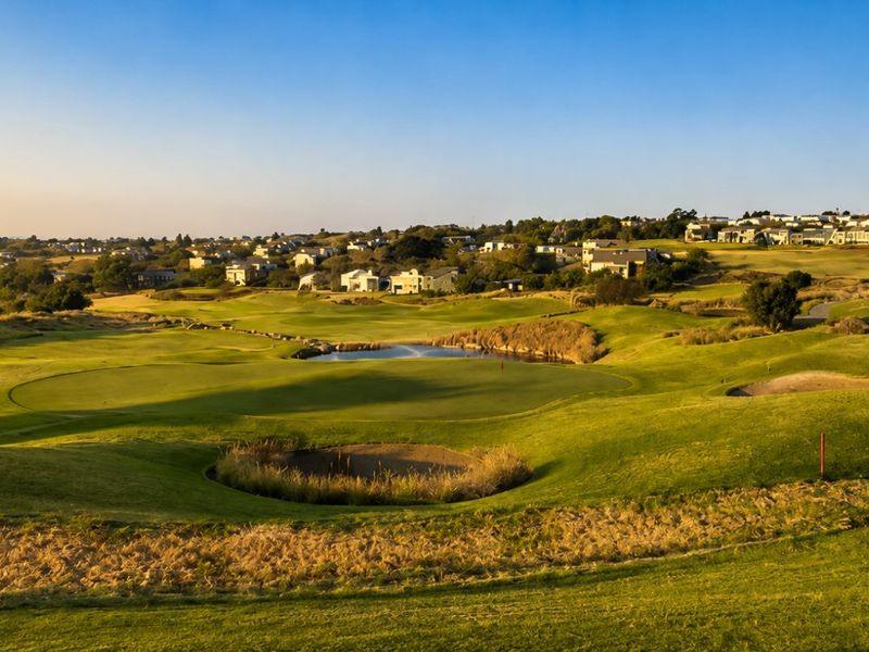 A scenic elevated view overlooking a well-maintained golf course and surrounding residential estate landscape.