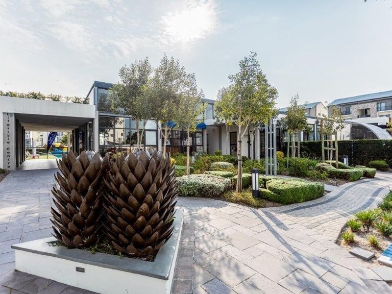 A well-maintained modern apartment complex lifestyle centre featuring paved walkways, landscaped gardens, and contemporary architectural design.