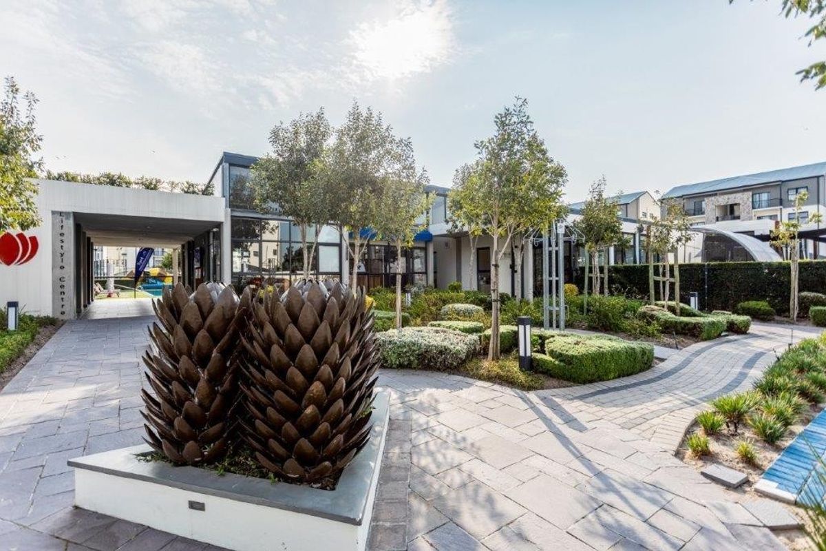 A well-maintained modern apartment complex lifestyle centre featuring paved walkways, landscaped gardens, and contemporary architectural design.