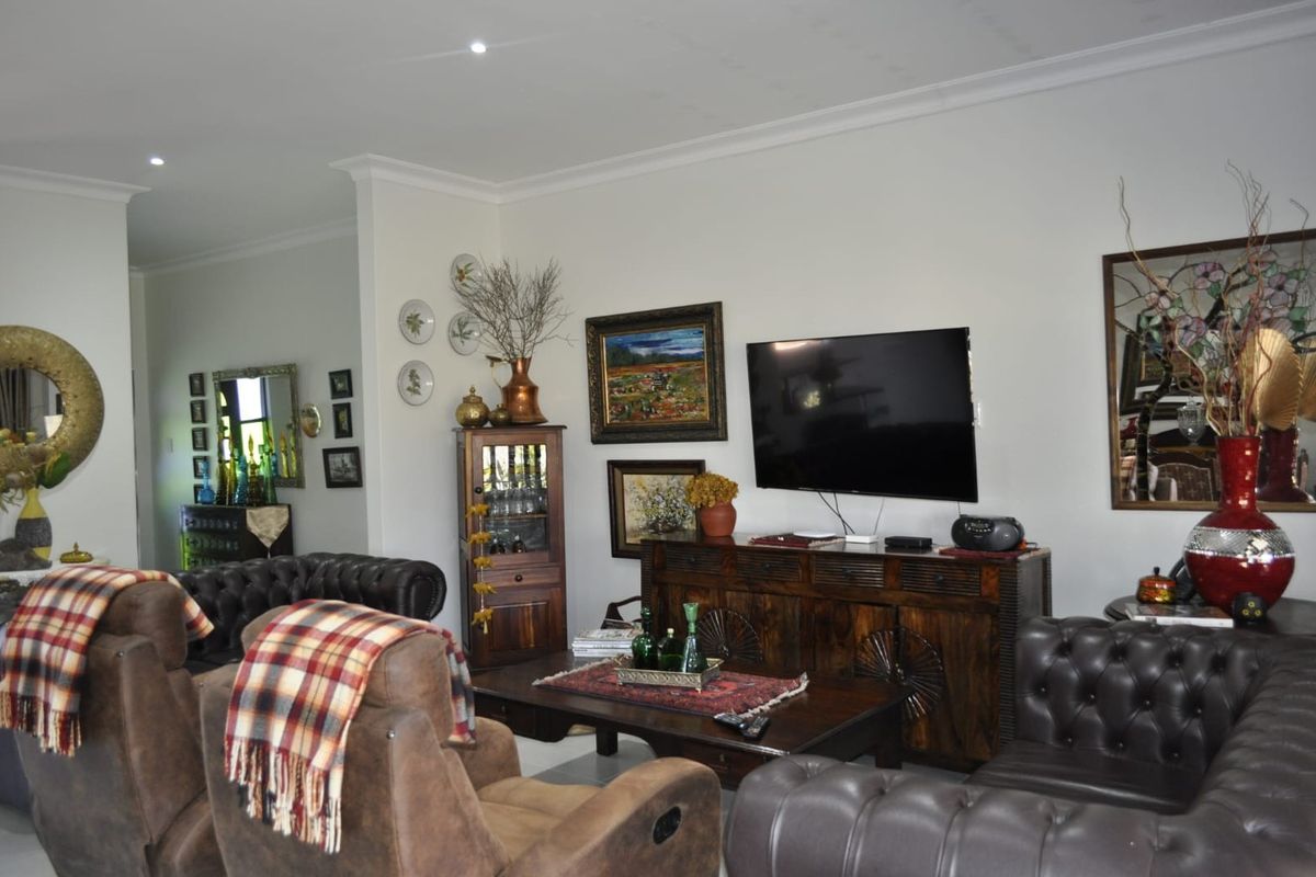 A comfortable living room featuring recessed downlighting and decorative ceiling cornicing, providing a neutral base for interior design updates.