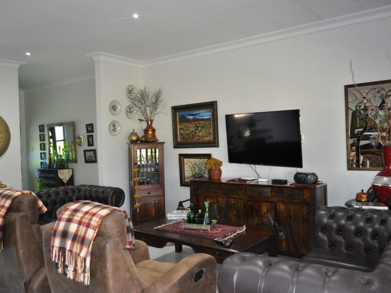 A comfortable living room featuring recessed downlighting and decorative ceiling cornicing, providing a neutral base for interior design updates.
