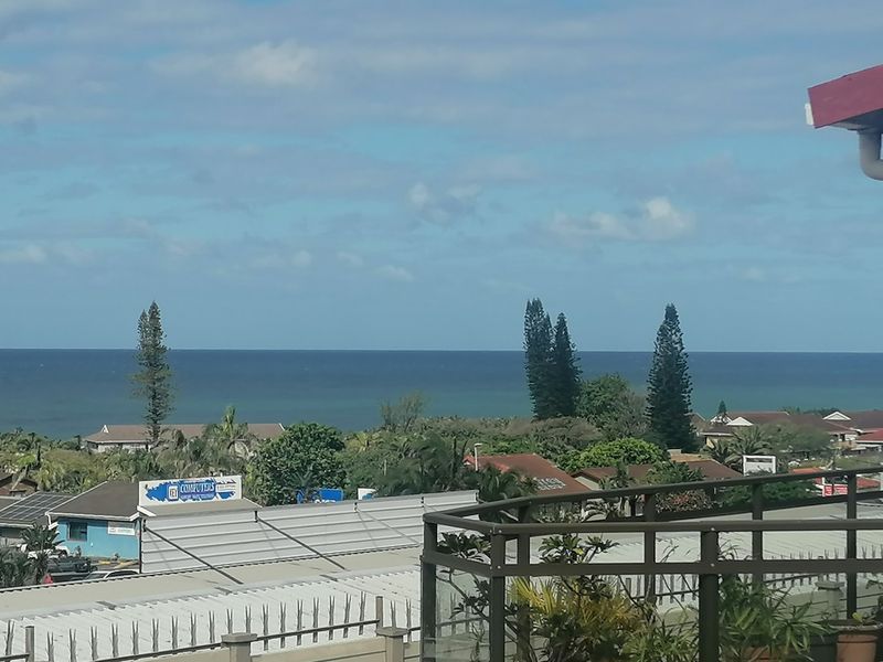 Elevated coastal view overlooking the surrounding neighborhood and ocean horizon from a balcony.