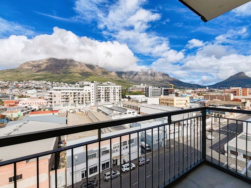 Elevated balcony view overlooking the city skyline with prominent mountain backdrop.