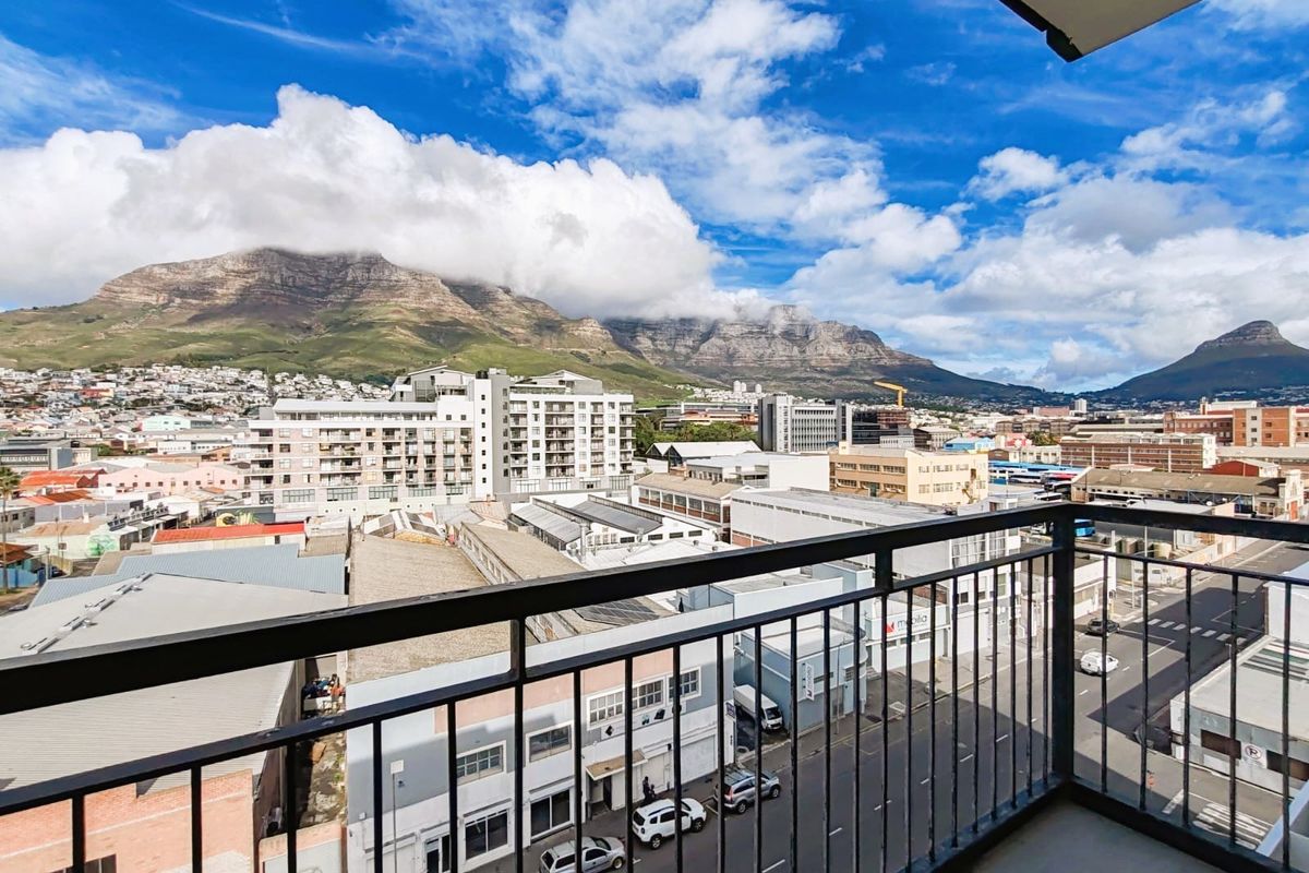 Elevated balcony view overlooking the city skyline with prominent mountain backdrop.