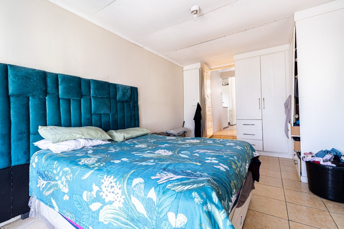 A bedroom featuring built-in wardrobes and tiled flooring, providing functional storage space.