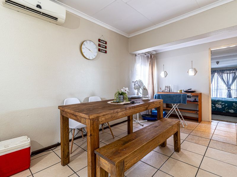 Dining area featuring ceramic floor tiles and a wall-mounted split-system air conditioner, providing a functional space for meals.