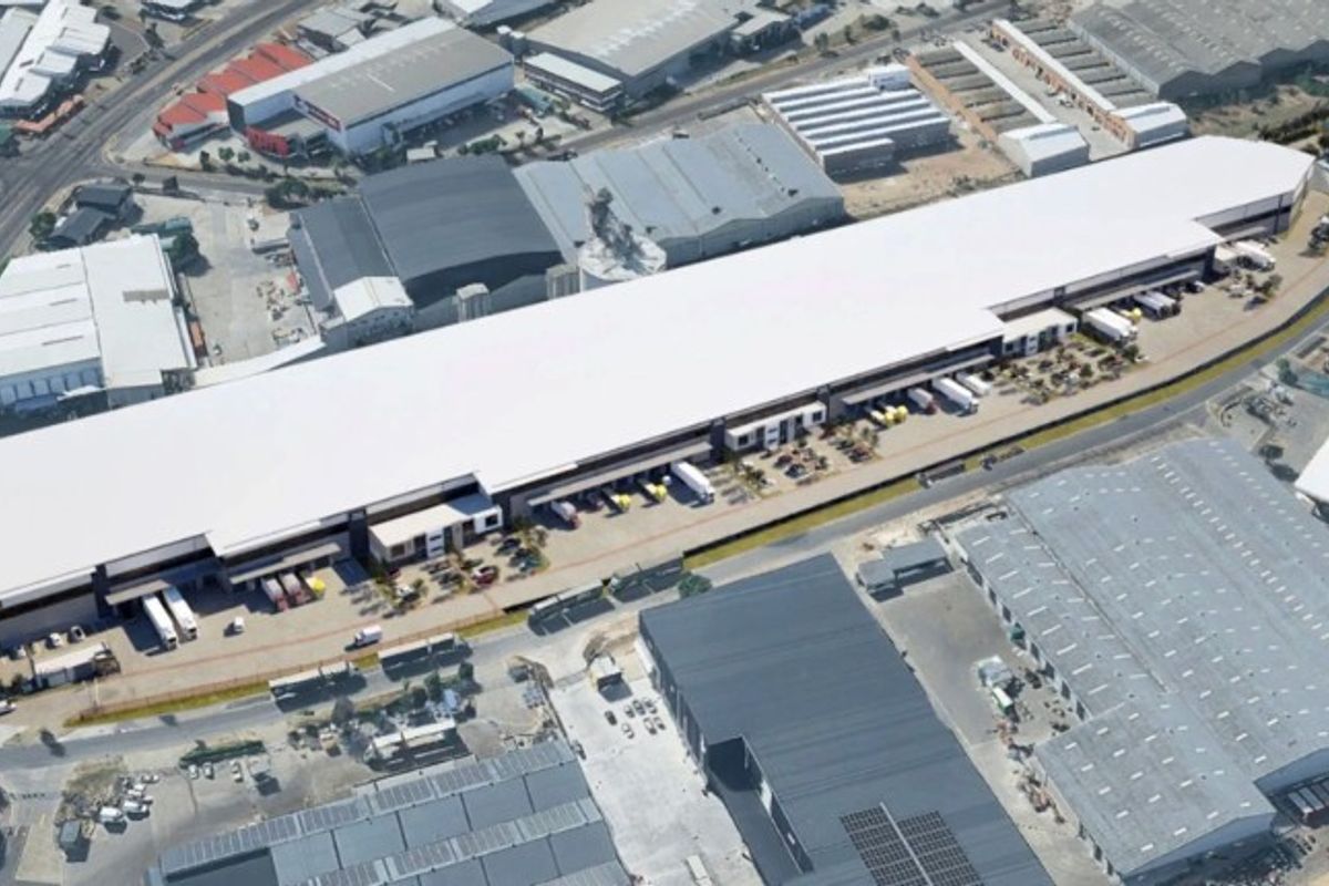 Aerial view of a large-scale industrial warehouse facility featuring extensive loading docks and a paved yard area within an industrial park.