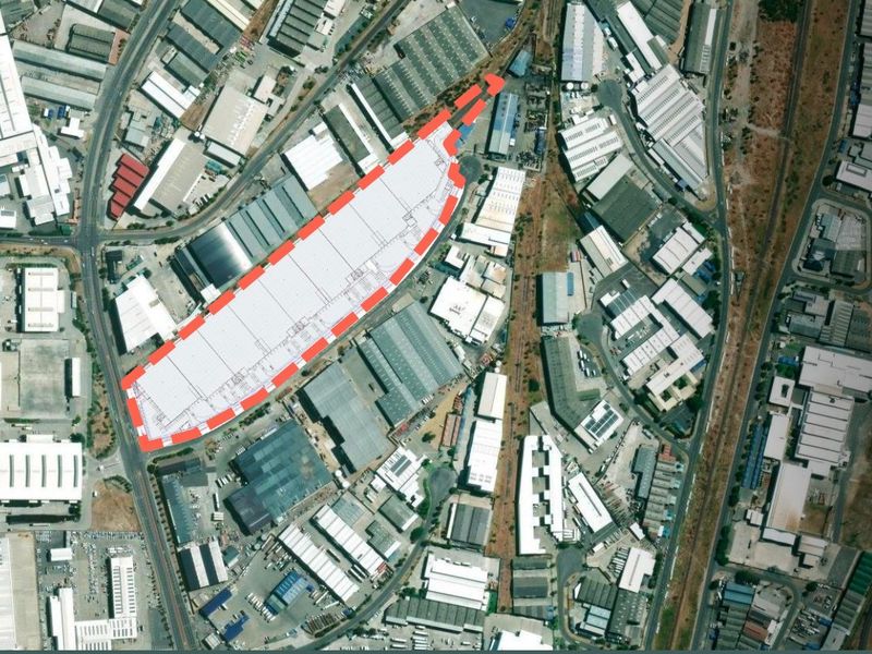 Aerial view of an industrial warehouse facility with a highlighted site boundary, situated within a developed industrial park.