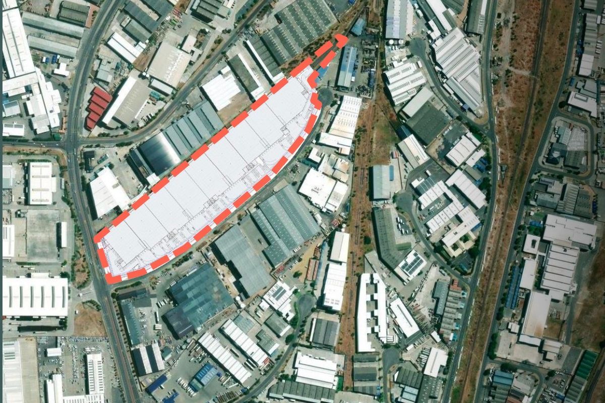Aerial view of an industrial warehouse facility with a highlighted site boundary, situated within a developed industrial park.