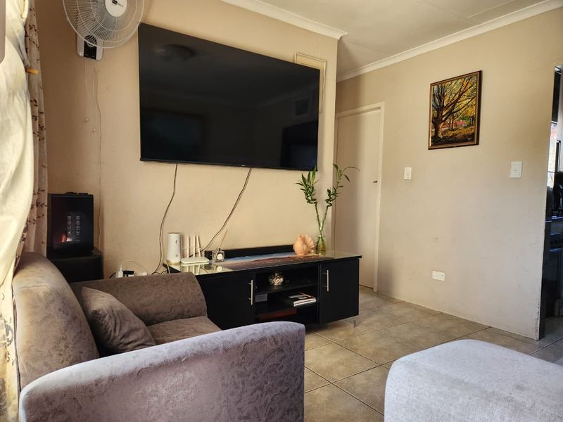 A living room area featuring tiled flooring and neutral wall finishes, providing a functional space for relaxation.