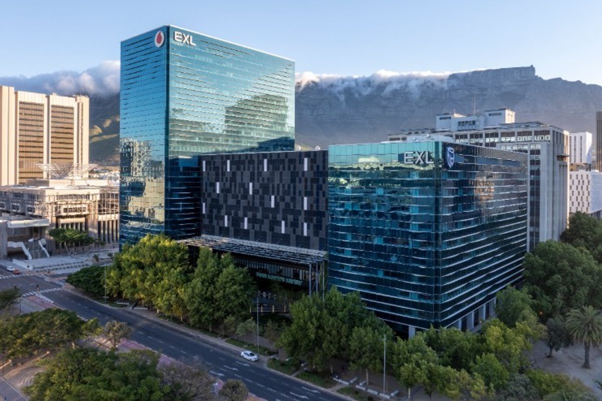 Aerial view of a modern commercial office complex featuring glass curtain wall facades, situated in an urban environment with surrounding greenery.