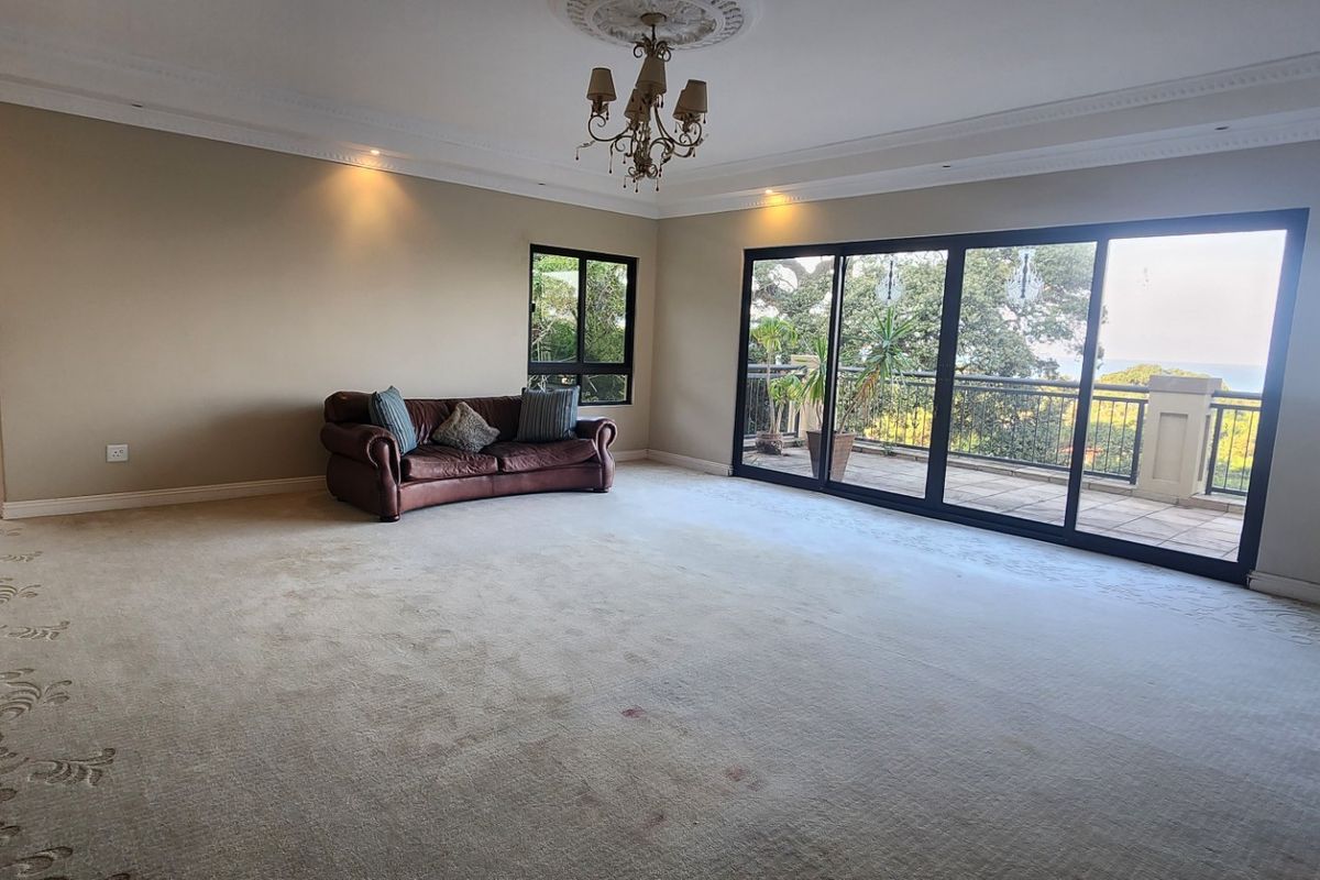 Spacious living room featuring large sliding glass doors leading to a balcony, decorative ceiling coving, and recessed lighting.