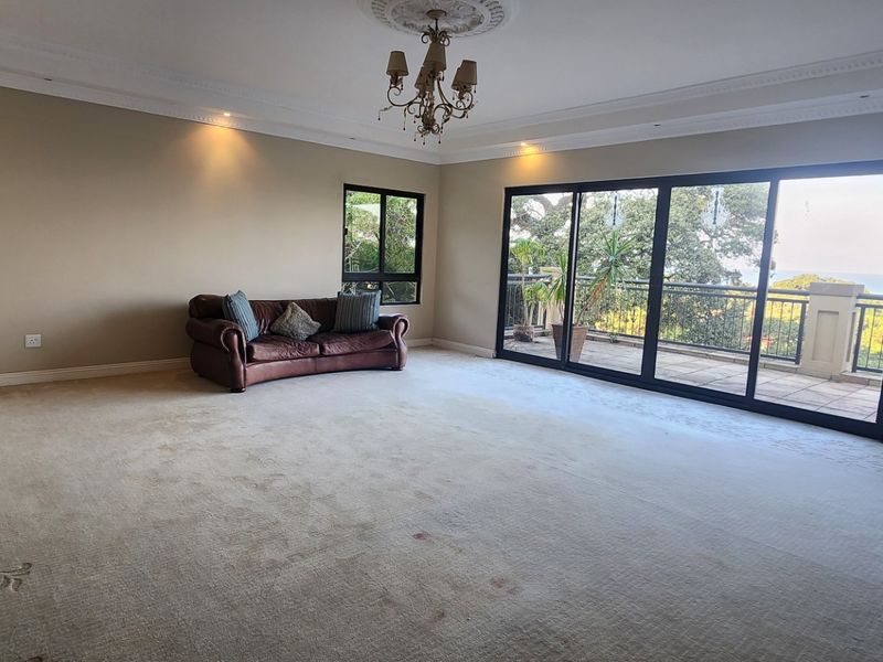 Spacious living room featuring large sliding glass doors leading to a balcony, decorative ceiling coving, and recessed lighting.