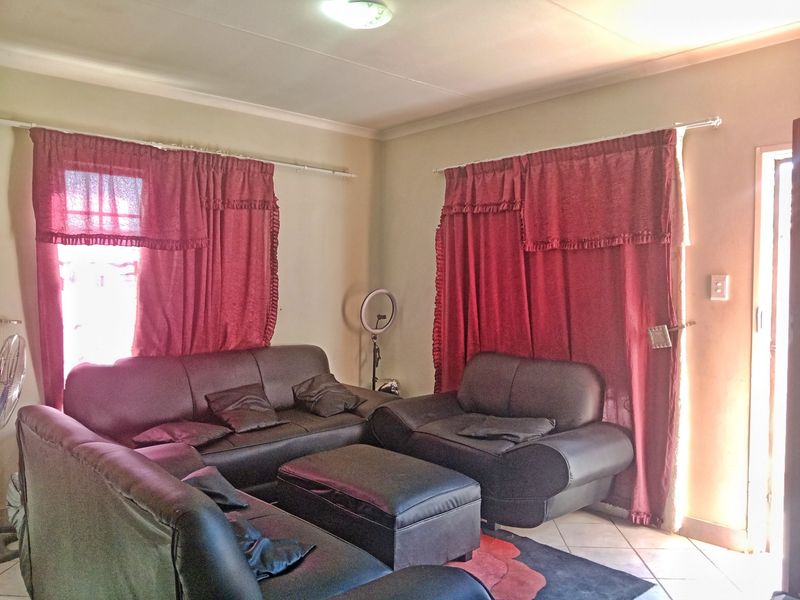A living room featuring tiled flooring and standard ceiling finishes, providing a functional space for relaxation.
