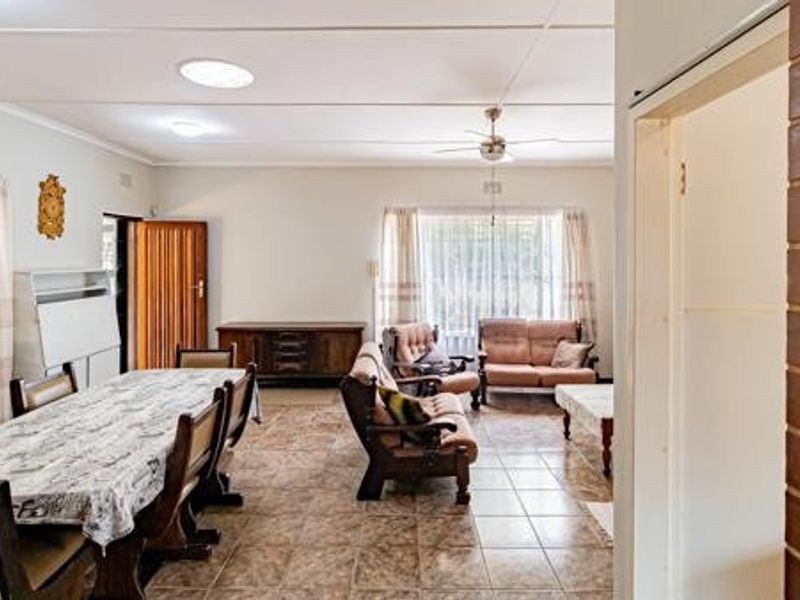 Spacious open-plan living and dining area featuring tiled flooring, a ceiling fan, and recessed lighting, offering a versatile layout for family living.