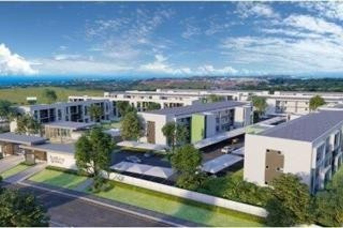 An aerial perspective of a modern apartment complex featuring multiple residential blocks, covered parking facilities, and landscaped outdoor areas.