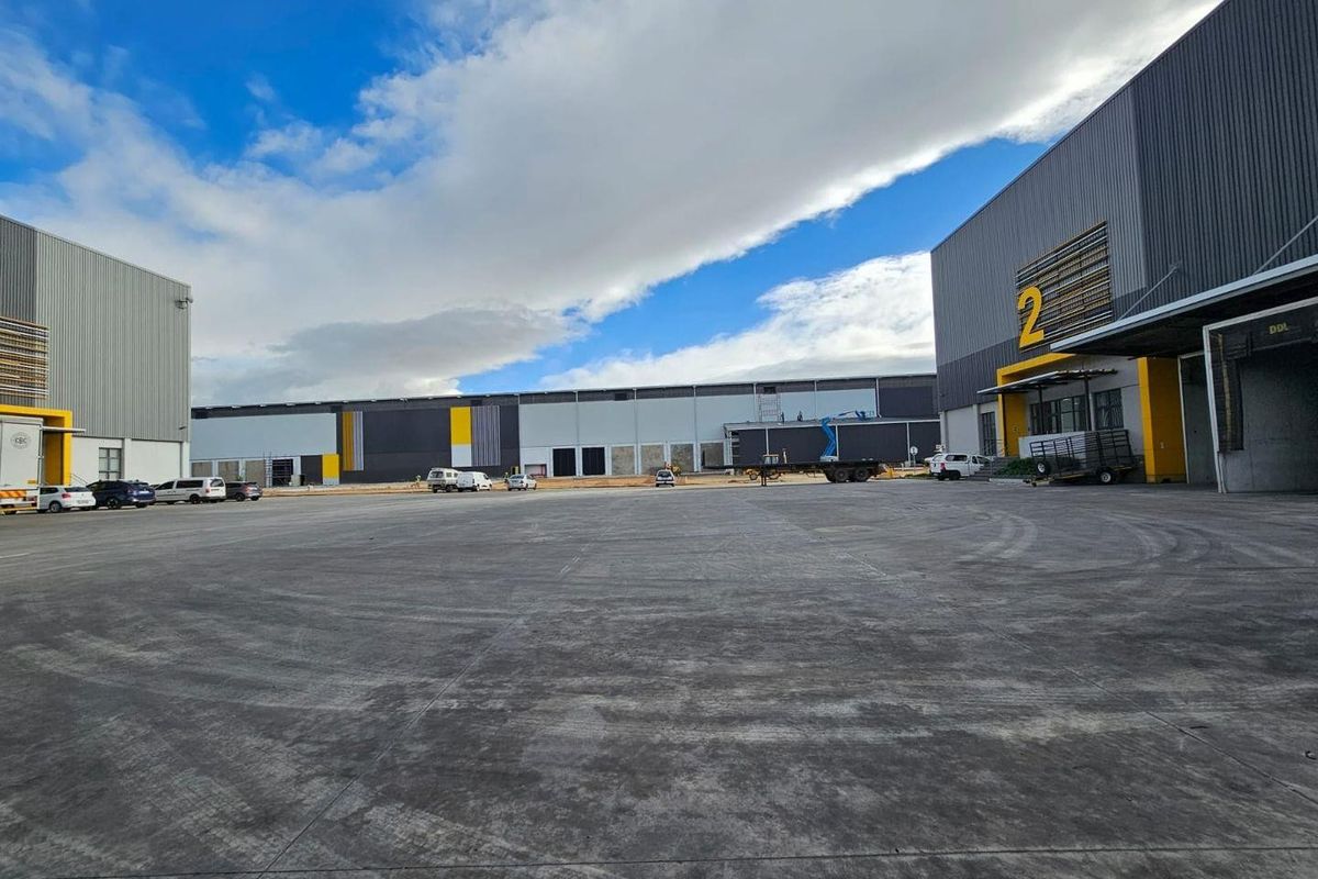 Spacious industrial concrete yard area serving multiple warehouse units with loading docks and modern metal cladding.